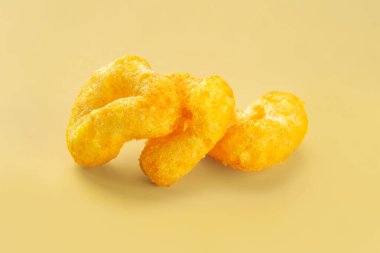 Çıtır çerezler. Sarı arka planda peynirli mısır çerezi yığını.