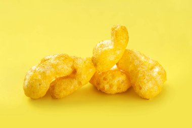 Çıtır çerezler. Sarı arka planda peynirli abur cubur yığını