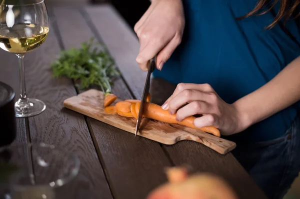 Žena řezání mrkev — Stock fotografie