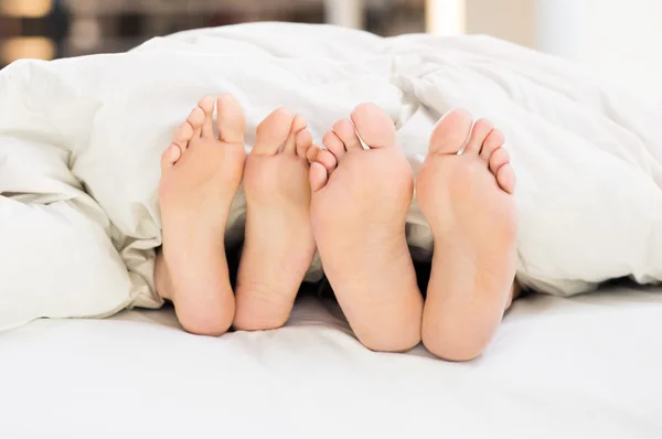 Beberapa kaki di tempat tidur — Stok Foto