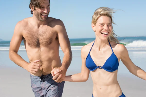 Pareja corriendo en la playa — Foto de Stock