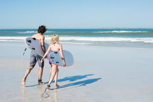 Couple surfing at ocean — Stock Photo, Image