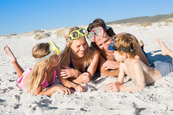 Семья на пляже с масками для подводного плавания — стоковое фото