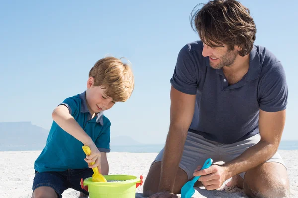 Junge spielt mit Vater am Strand — Stockfoto