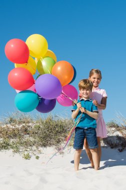 küçük erkek ve kız balonlar holding