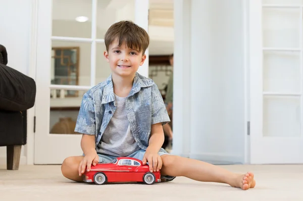 Мальчик играет с игрушечной машиной — стоковое фото