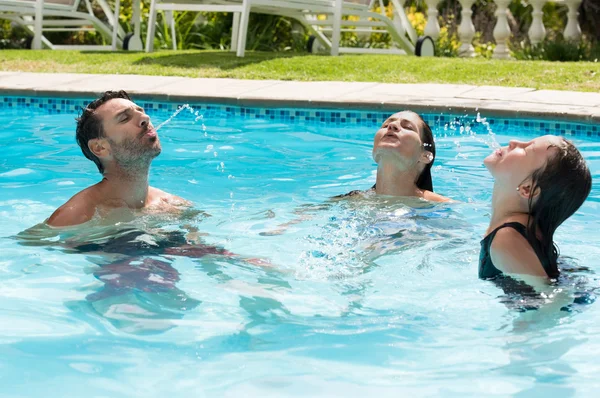 Familia jugando en la piscina — Foto de Stock