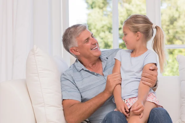 Chica sonriendo con el abuelo — Foto de Stock