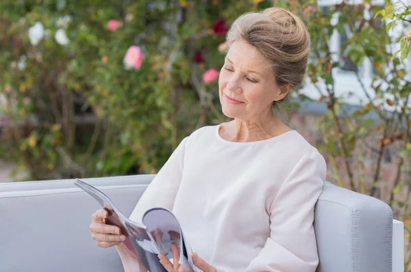 Starszy kobieta czytania magazynu — Zdjęcie stockowe