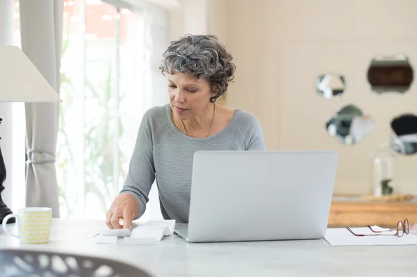 Seniorin prüft Rechnungen — Stockfoto