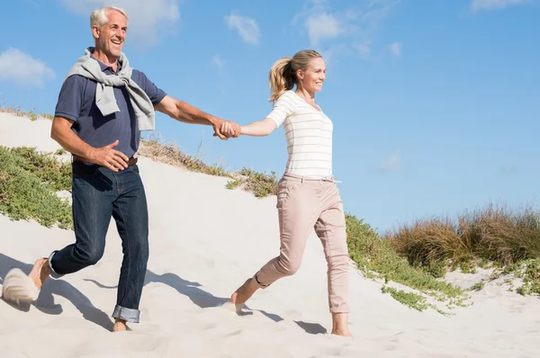 Paar rennt Düne hinunter — Stockfoto