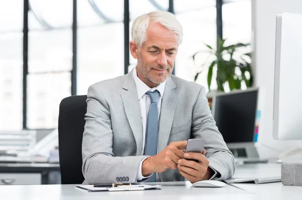 Hombre de negocios sénior mensajes de texto con teléfono celular — Foto de Stock