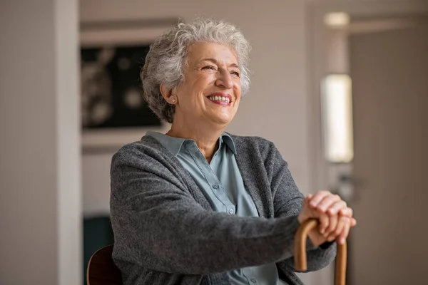 Pensionerad Äldre Kvinna Skrattar Med Sin Träkäpp Medan Kopplar Hemma — Stockfoto