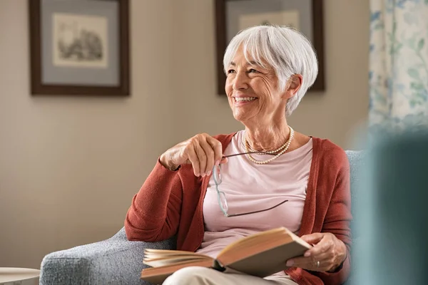 Весела Старша Жінка Тримає Книгу Окуляри Думаючи Відпочиваючи Вдома Щаслива — стокове фото
