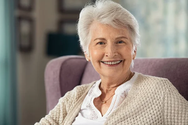 Portret Van Een Vrolijke Oude Vrouw Zittend Een Fauteuil Kijkend — Stockfoto