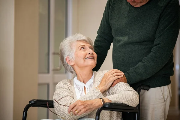 남편은 요양원에서 아내를 바라보면서 휠체어를 아내를 합니다 장애인 센터에서 행복하게 — 스톡 사진