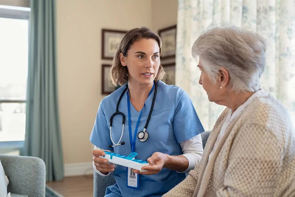 Молодая Медсестра Объясняет Дозировку Лекарств Пожилым Пациентам Центре Уходу Больными — стоковое фото