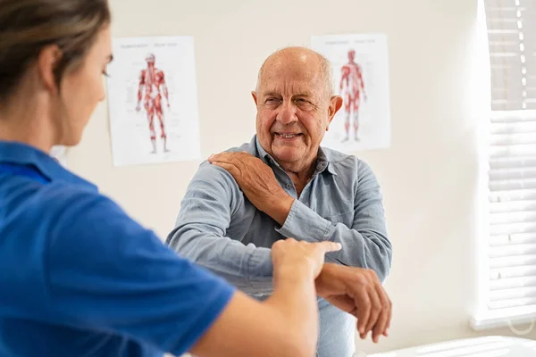 Young Woman Physiotherapist Helping Senior Man Elbow Exercise Clinic Young — Stock Photo, Image