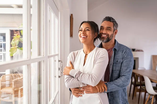 Lächelndes Erwachsenes Paar Das Sich Umarmt Und Fenster Steht Während — Stockfoto