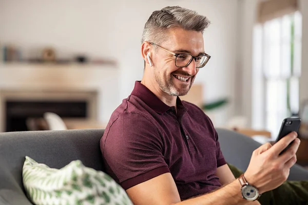 Χαμογελώντας Ώριμος Άντρας Γυαλιά Ηλίου Χρησιμοποιώντας Smartphone Στο Σπίτι Όμορφος — Φωτογραφία Αρχείου