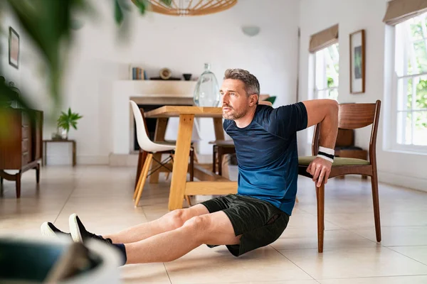 Reifer Mann Beim Fitnesstraining Während Liegestütze Mit Stuhl Wohnzimmer Macht — Stockfoto