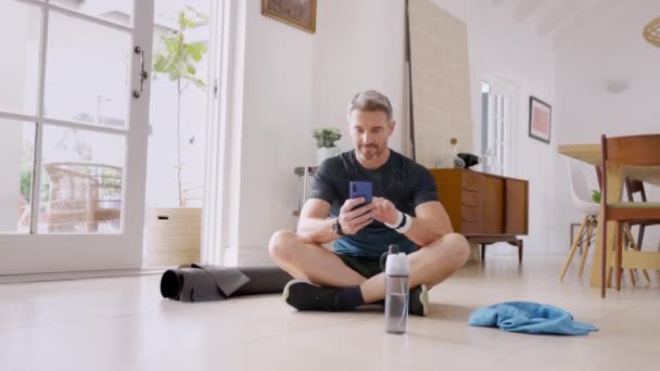 Reifer Gutaussehender Mann Mit Smartphone Beim Sport Hause Fitnessmann Mittleren — Stockvideo