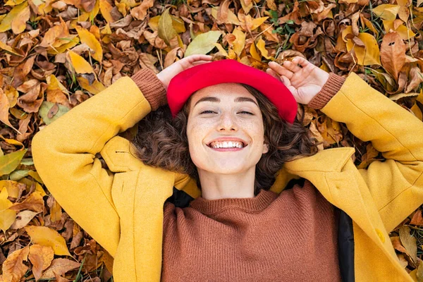 Mulher Sorridente Feliz Deitada Sobre Folhas Amarelas Olhando Para Câmera — Fotografia de Stock