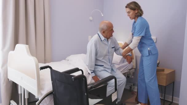 Lovely Nurse Assisting Senior Man Get Bed Hospital Caring Nurse — Stock Video