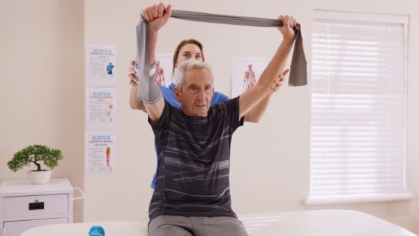 Joven Fisioterapeuta Trabajando Con Paciente Mayor Centro Rehabilitación Entrenador Asistiendo — Vídeos de Stock