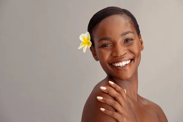 面带微笑的中年非洲女人 头发长满了乳白色的花 带着大大的笑容看着相机 美丽的黑人女性的肖像在背景上与复制空间隔离 水疗后心满意足的成熟女士 — 图库照片
