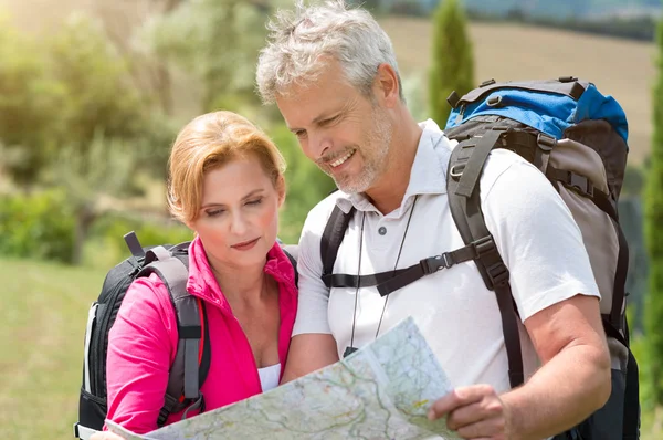 Reifer Wanderer schaut auf Landkarte — Stockfoto