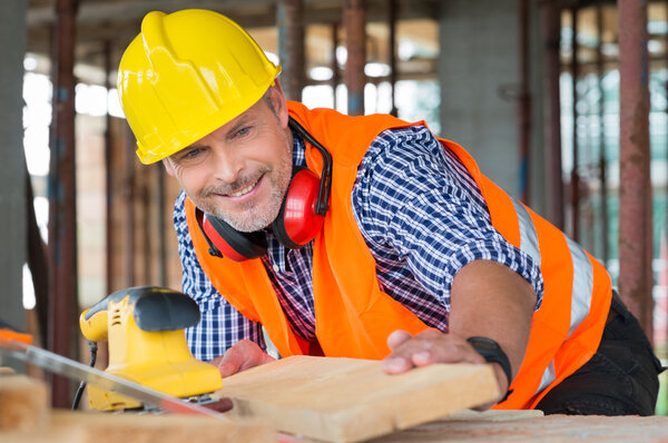 Carpenter Examining Plank