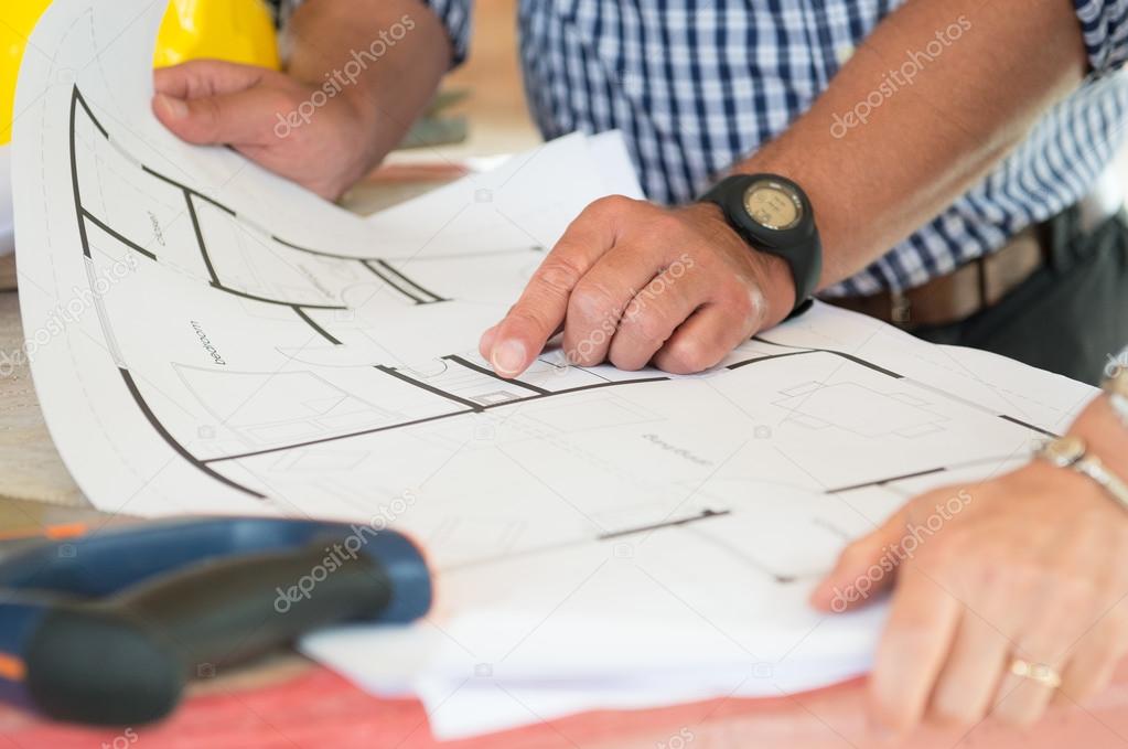 Architect Showing Plan On Blueprint