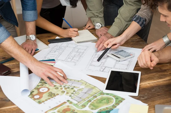 Equipe de arquitetos discutindo sobre plantas — Fotografia de Stock