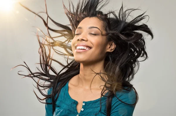 Smiling young woman blowing her hair — Stock Photo, Image