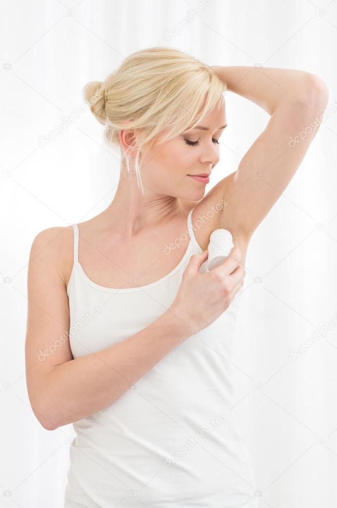 Woman applying deodorant