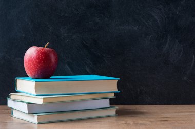Elma ve bir kitap yığını