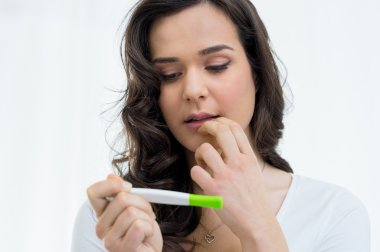 Woman looking at pregnancy test clipart
