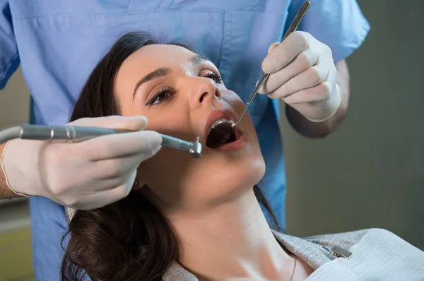 Tandlæge arbejder på patientens tænder - Stock-foto