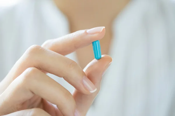 Hand holding blue capsule pill — Stock Photo, Image