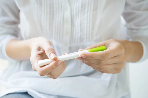 Mujer sosteniendo prueba de embarazo —  Fotos de Stock