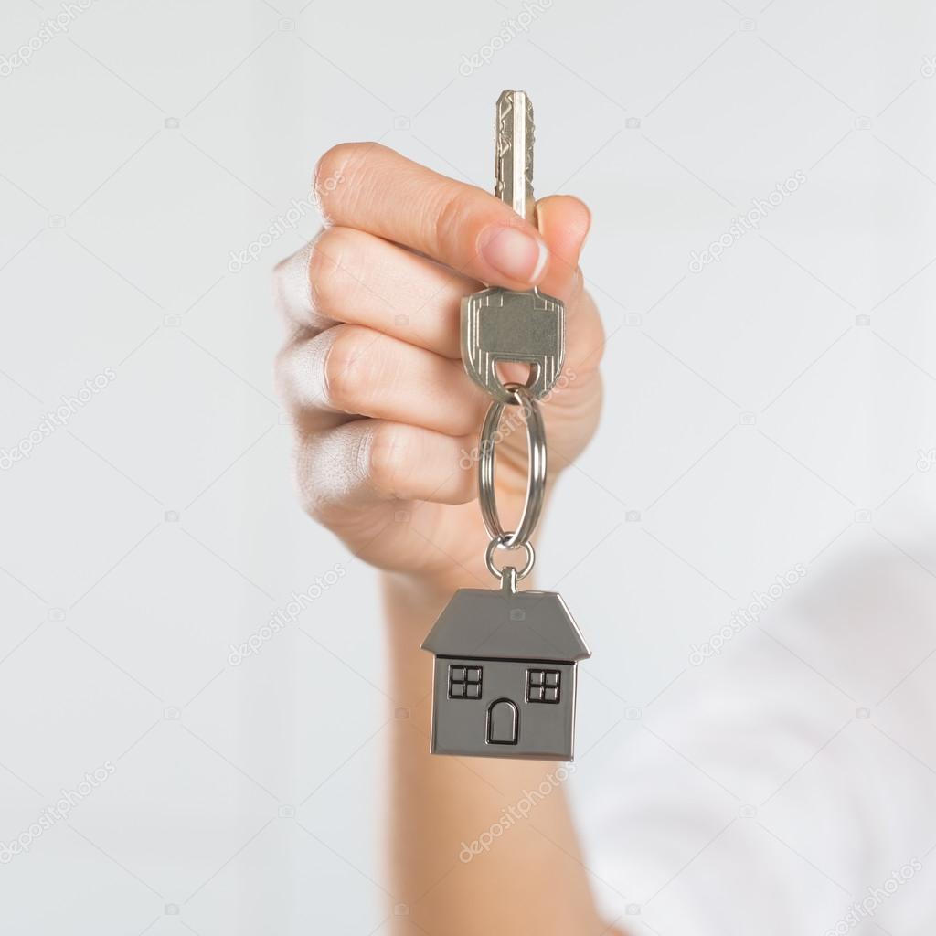 Woman holding key with small house