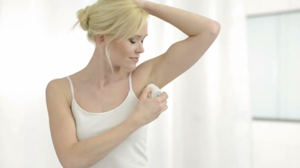 Woman applying deodorant to her armpit — Stock Video