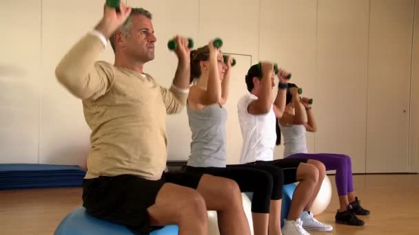 Gente levantando pesas en el gimnasio — Vídeo de stock