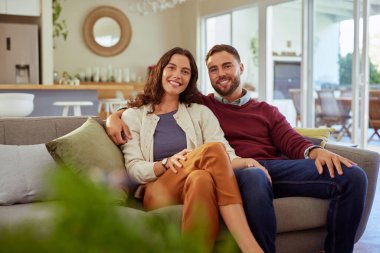 Rahat bir anın tadını çıkarırken, oturma odasındaki kanepede yan yana oturan sıradan bir erkek ve güzel bir kadın. Evdeki koltukta oturup kameraya bakan orta yaşlı ortakların portresi. Mutlu çift hafta sonunu birlikte geçiriyor.