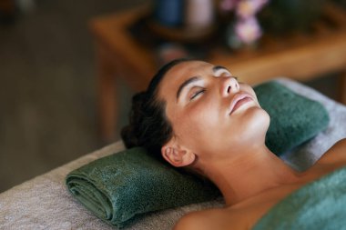 Masaj masasına uzanmış gözleri kapalı bir kadın. Tatil köyünde kaplıcada eğlenen genç Latin kadın. Lüks otellerde rahatlayan sakin bir kız..