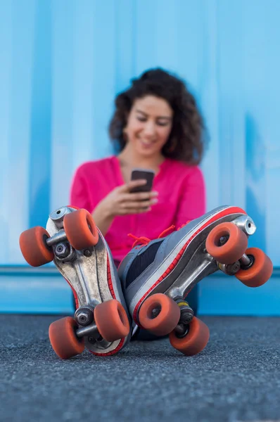Young female skater using cellphone — Stock Photo, Image