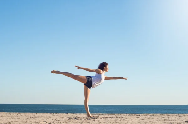 Kadın plajda yoga yapıyor. — Stok fotoğraf