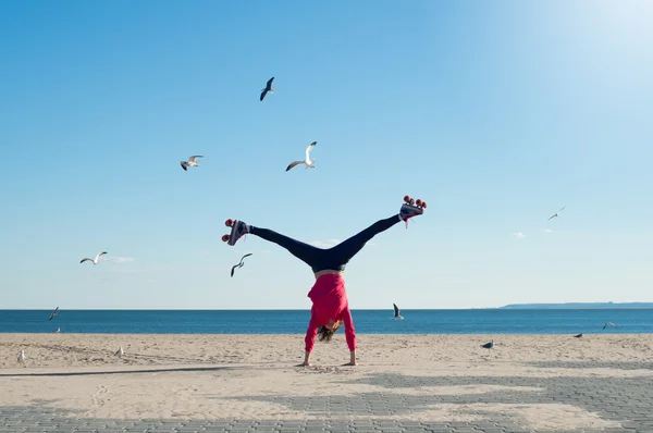 Ung kvinna gör cartwheel Stockbild