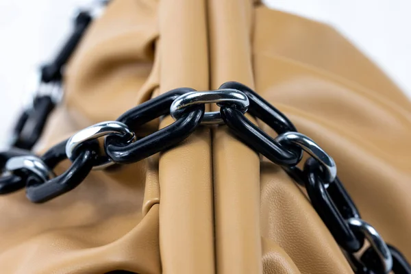 Close up of the chain of a ladies handbag. Leather bag with black string. Fashion concept  Luxury leather woman\'s handbag. black cord of a fashionable bag. detailed Top view